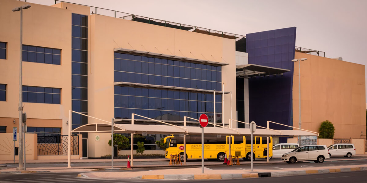 Modern school campus building and bus transport in Abu Dhabi